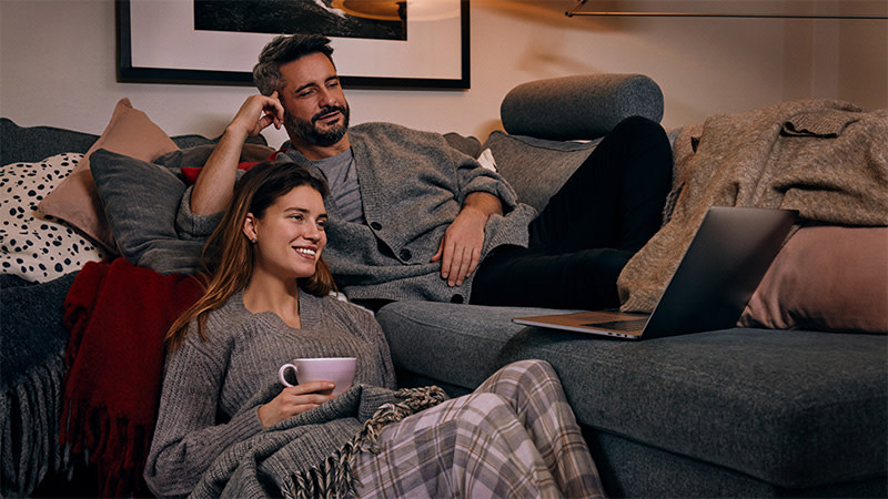 Par som sitter i soffan och tittar på TV4 Play via datorn